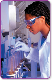 A scientist performs an experiment in a laboratory wearing protective clothing