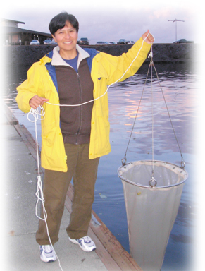 A photograph of Dr. Scottie Yvette Henderson. She is holding a net to catch crab.