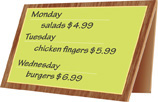 A specials sign lists Monday, salads $4.99; Tuesday, chicken fingers $5.99; Wednesday, burgers $6.99.