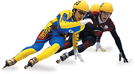 Olympic speed skaters compete on ice, with the skater in yellow and blue gear in the lead. Both the skaters wear yellow helmets. 