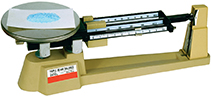 A triple beam balance with a chit of paper on it.