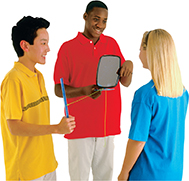 Three young people stand in a cirlce, face each other; one boy holds a mirror, the second boy holds a wand, and the girl is faces the boys and observes.