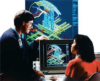 A man and a woman look at a digital design on the computer, which is also projected on a screen in front of them.