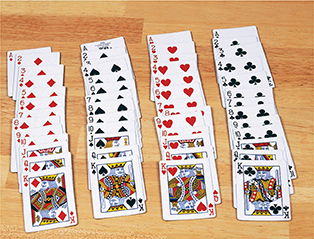 A deck of cards organized into four vertical rows according to suit. Aces are at the top and the cards move in numeric order with Kings at the bottom. 
