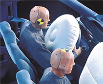 Two test dummies in a car with airbags blown out in front of them.