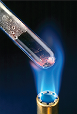 A test tube being burned at the end tip over a flame.