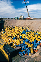 Large containers dumped into a landfill.