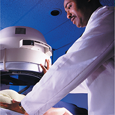 A man in a lab coat performing a test on a patient through the use of an imaging machine.