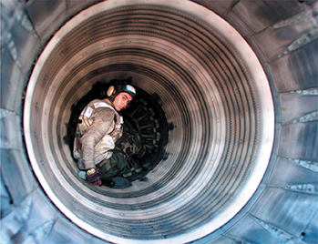 Photof of an engineer inside the tunnel of an aircraft or shuttle.