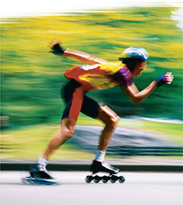 Photo of a person on rollerblades in motion. The background is blurred to reflect that the skater is moving fast. 