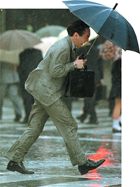 A man being pushed by the wind in the rain. The wind represents the force.