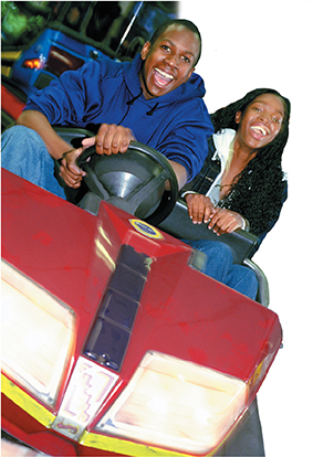 A girl and boy riding in a bumper car.