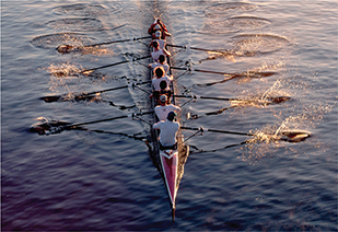Eight rowers in a boat pull on their oars.