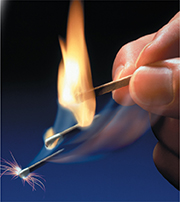 A hand holding a lit match.  Showing how it changes from a spark to a flame.
