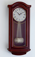 A wall clock that has a pendulum. The pendulum is given the illusion that it is swaying back and forth.  