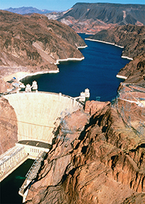  The Hoover Dam surrounded by mountains  on both sides.
