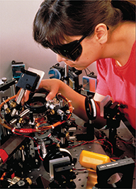 A physicist wearing safety glasses uses a laser.