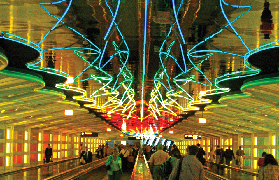 An airport walkway lit with neon lights. 