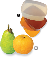 A stack of transparent soap, a pear and an orange.