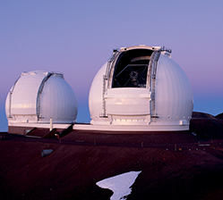 Two big telescopes shaped like large golf balls on the summit of Hawaii’s dormant Mauna Kea volcano. 
