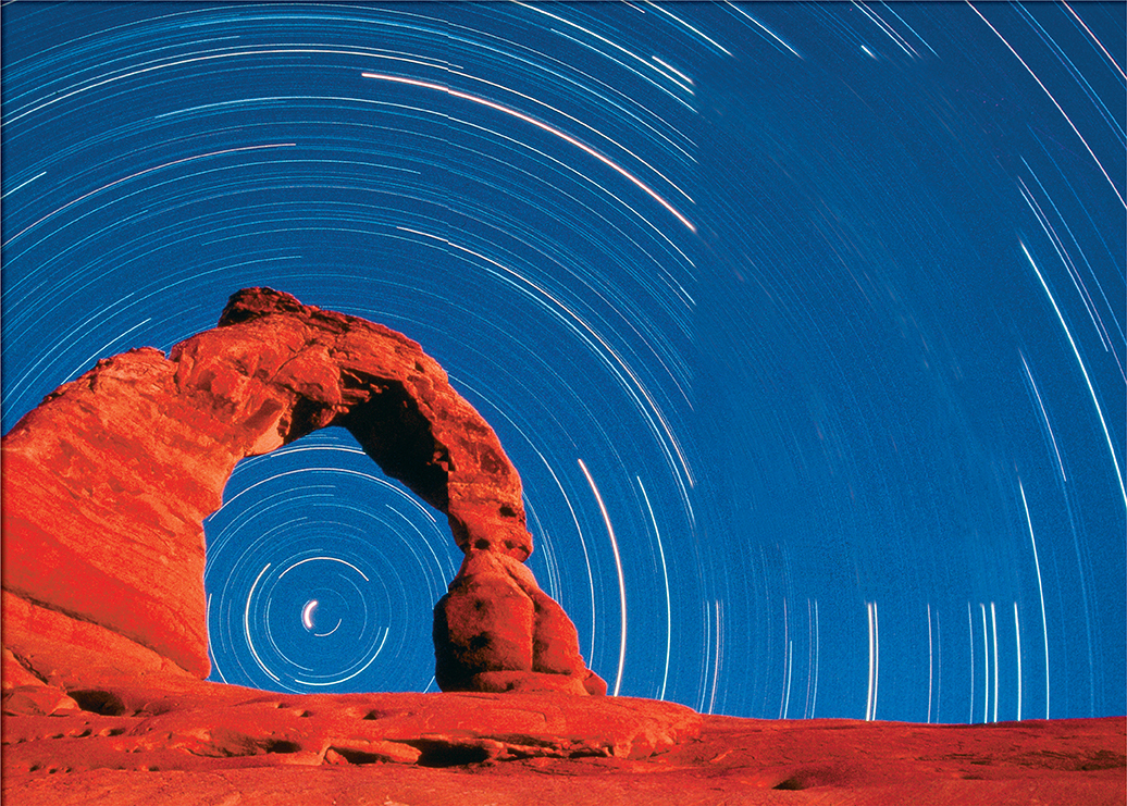 A natural stone arch with stars in the background moving in a circular pattern.