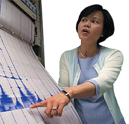A female seismologist reading  a report. 