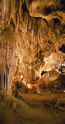 A cave full of stalactite hanging from the ceiling resembling long icicles, and stalagmite pillars on the floor. This is a result of chemical weathering.