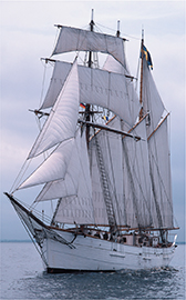 A ship with many sails on a body of water.
