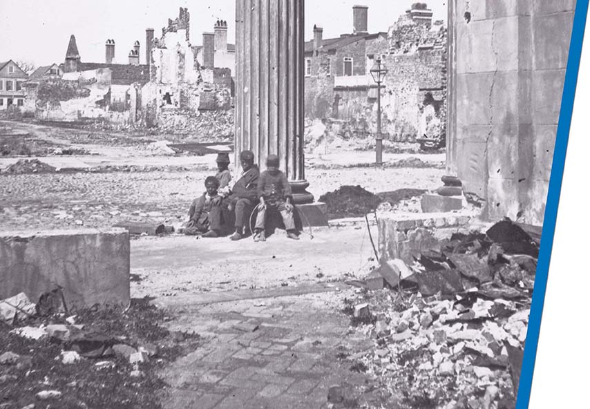 A photograph of African-American children sitting against a pillar in a destroyed town.