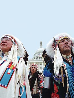A photo of Native Americans in full traditional dress with the U.S. Capital in the background.