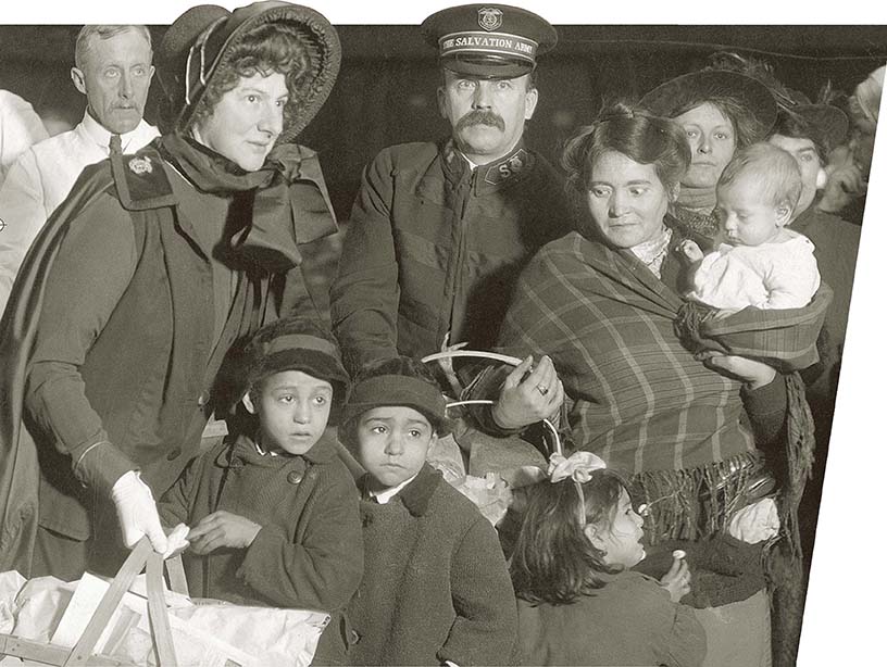 A Salvation Army man and woman giving baskets to a family.