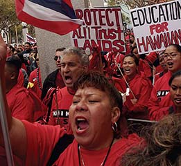 A photo of Hawaiian protestors holding placards .