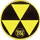 A sign with three yellow triangles on a black background that represents a fallout shelter.