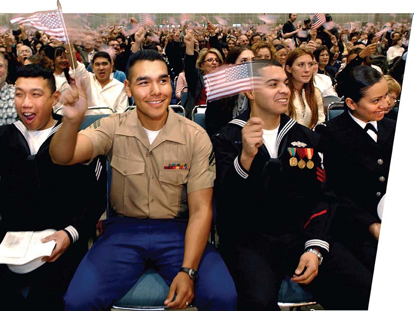 Immigrants waving flags at a naturalization ceremony.