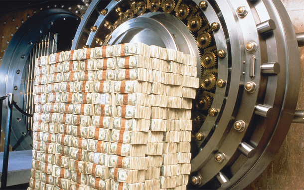 A photo of an open vault with a large stack of cash.